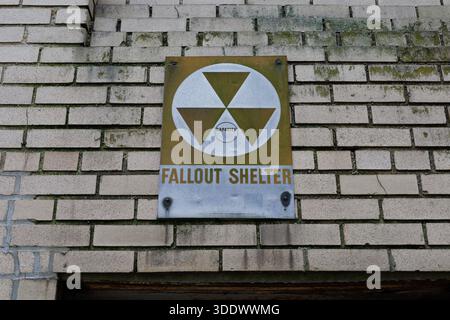 Verblasstes Vintage-Fallout Shelter-Schild über einem Eingang im Keller der Wohnung in Manhattan, New York City. Relikt aus der Zeit des Kalten Krieges. Stockfoto