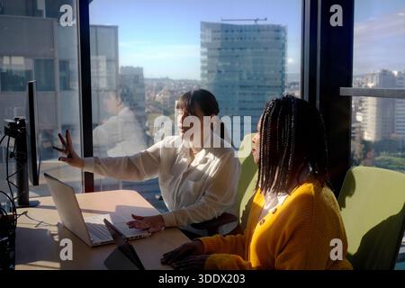 Zwei Frauen diskutieren ein Projekt in einem modernen Büro Stockfoto