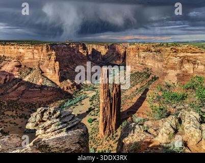 Der Spider Rock erhebt sich 800 Meter vom Boden des Canyon de Chelly und ist ein markanter Sandsteinturm, der von roten Klippen und tiefen Schatten umgeben ist. Stockfoto