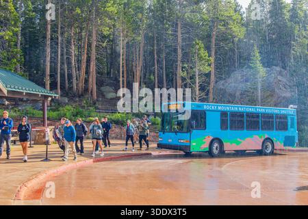 Colorado, 4. JUL 2025 - regnerischer Blick auf einen Shuttlebus, der Besucher am Bear Lake Trailhead im Rocky Mountain National Park abbringt Stockfoto