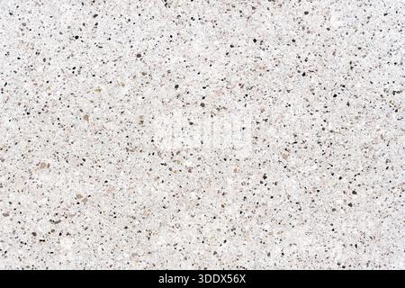 Hochauflösende Ansicht einer weißen Terrazzo-Oberfläche. Moderne Steinstruktur mit kleinen grauen und braunen Kieselsteinen, ideal für architektonisches Design und Luxusausstattung Stockfoto