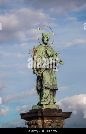 Statue des heiligen Johannes von Nepomuk mit goldenem Stundenlicht auf Bronzerelief an der Karlsbrücke, Prag, Tschechische Republik. Stockfoto