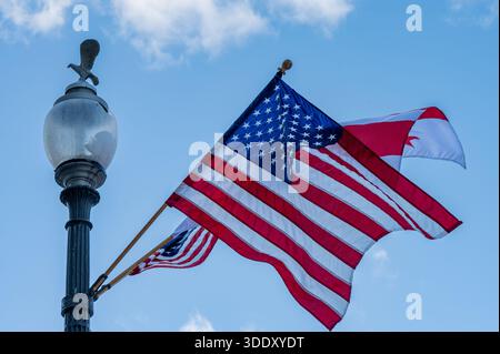 US-amerikanische und kanadische Flaggen, die auf einem Straßenlaternenpfosten entlang der Pennsylvania Avenue in Washington, DC, im Januar 2025 fliegen. Stockfoto