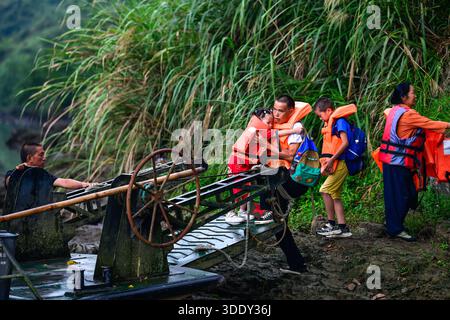 (260104) -- PEKING, 4. Januar 2026 (Xinhua) -- Ren Dabing (3. R) begleitet Schüler auf ihrem Weg zur Schule auf dem Weg zum Fluss Huayuan zwischen der Provinz Guizhou im Südwesten Chinas und der Provinz Hunan in Zentralchina, 9. September 2025. Ren ist Lehrer an der Molao Youyi Primary School im Dorf Molao in der Provinz Hunan. Das Dorf liegt am Fluss Huayuan, der die Grenze zum Dorf Wansen in der Provinz Guizhou bildet. Um diese Schule zu besuchen, die von den beiden Provinzen gemeinsam gegründet wurde und von ihnen verwaltet wird, müssen Schüler aus Wansen eine Fähre über den Fluss nehmen. (Xin Stockfoto