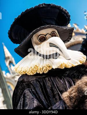 Venedig, Italien - 11. Februar 2018: Person, die während des berühmten Karnevals von Venedig in Italien eine traditionelle Pestdoktorenmaske und historische Kostüme trägt. Stockfoto