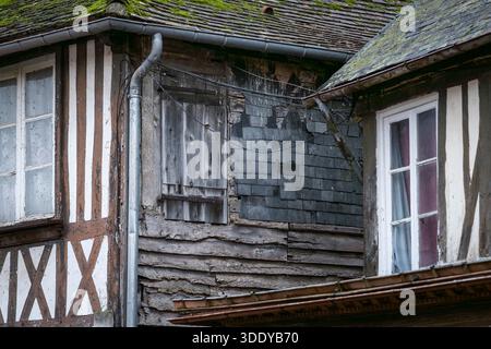 Nahaufnahme eines alten Fachwerkhauses mit verwitterter Fassade, moosbedecktem Dach und traditioneller Architektur. Historisches Fachwerkhaus. Stockfoto