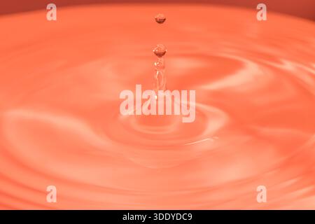 Wassertropfen spritzen in einem Glas blau Stockfoto