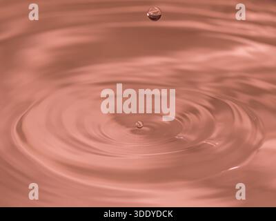 Wassertropfen spritzen in einem Glas blau Stockfoto