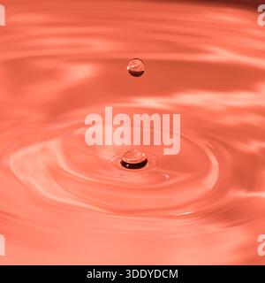 Wassertropfen spritzen in einem Glas blau Stockfoto