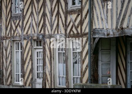 Traditionelle Fachwerkhausfassade mit Holzbalken und kleinen Fenstern in einer historischen französischen Stadt. Nahaufnahme eines alten Fachwerkgebäudes. Stockfoto