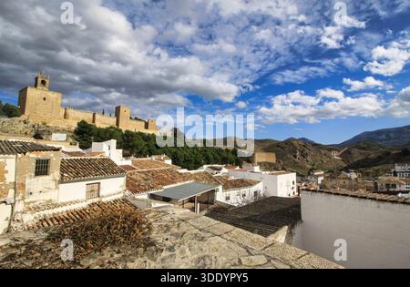 Eine malerische urbane Landschaft von Antequera in Andalusien mit der maurischen Festung (Alcazaba) und ihren Wachtürmen auf einem Hügel. Stockfoto