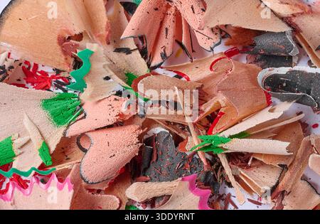 Nahaufnahme eines Haufens Spiralspäne von scharfen Farbstiften auf weißem Hintergrund, von oben gesehen. Stockfoto