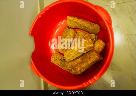 Traditionelles kretisches Apaki (geräuchertes Schweinefleisch) mit Kräutern und Gewürzen, zubereitet in einem großen Becken für festliche kulinarische Zwecke. Authentische lokale Gastronomie. Stockfoto