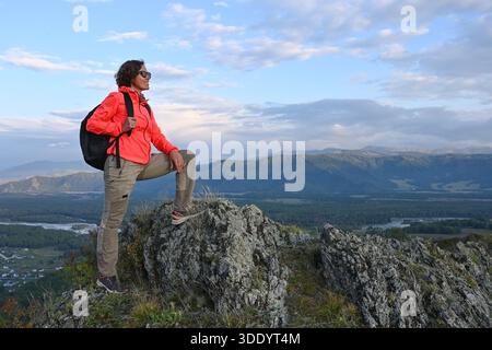 Weibliche Touristen mittleren Alters genießen einen Blick auf die Berge am Rande einer Klippe Stockfoto