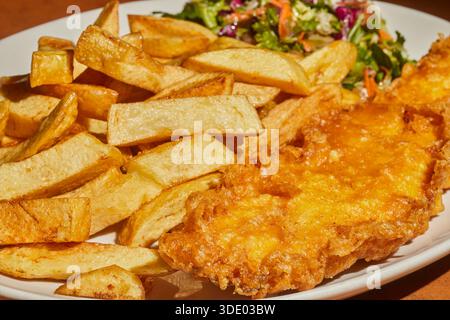 Ein Teller mit Fish and Chips, serviert im Golden Chippy in Grenwich, England. Einzigartig ist, es gibt einen grünen Salat auf dem Teller. Stockfoto