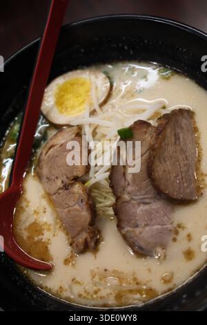 Eine köstliche Schüssel traditioneller japanischer Ramen mit Schweinefleisch, Ei, Nudeln und geschmackvoller Brühe. Stockfoto