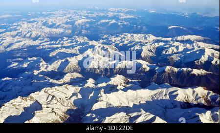 Das Bild zeigt eine Luftaufnahme der schneebedeckten Pyrenäen. Die Landschaft bietet Gipfel und Täler unter einem blauen Himmel mit freiem Raum für Stockfoto
