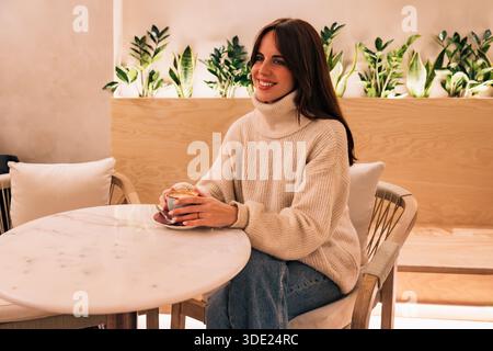 Frau genießt Kaffeepause in einem gemütlichen Café Stockfoto