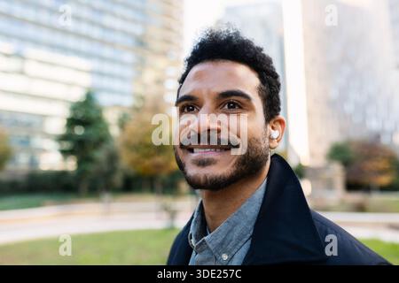 Junger Erwachsener lateinamerikanischer Geschäftsmann, der draußen lächelt Stockfoto