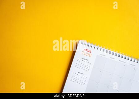 Tischkalender April 2026 auf gelber Oberfläche. Draufsicht, Kopierraum. Stockfoto