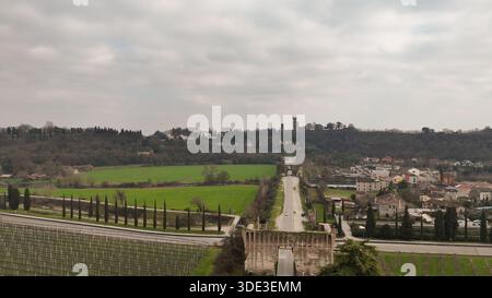 Panoramablick auf Valeggio sul Mincio, Italien, mit sanften Hügeln, Weinbergen, einer historischen Straße, und alte Architektur unter einem bedeckten Himmel Stockfoto