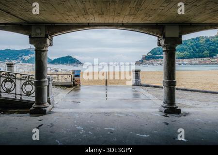 La Concha Bay und Santa Clara Island eingerahmt von Steinbögen und Säulen, San Sebastian, Spanien Stockfoto