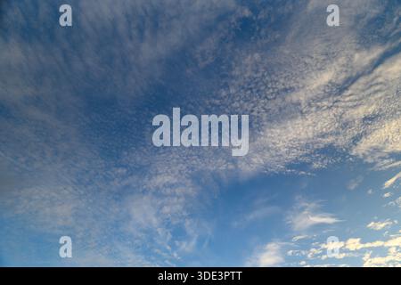 Ein weitläufiger und atemberaubender Blick auf einen ruhigen, weiten Himmel voller weicher, flauschiger Wolken und tiefblauer Farben Stockfoto