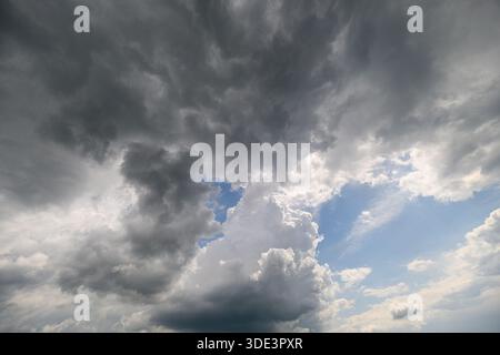 Ein atemberaubender und atemberaubender Blick auf einen dramatischen Himmel voller dunkler Wolken, während helles Blau hindurchschaut Stockfoto