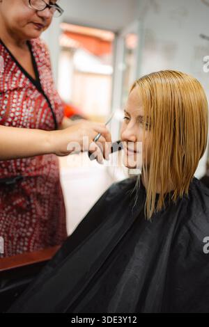 Friseur schneidet Kundenhaare in einem Salon Stockfoto