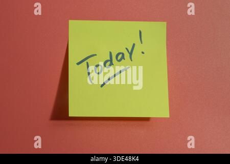 Gelbe Haftnotiz mit dem HEUTIGEN TEXT auf dunkelrosa Tafel Stockfoto