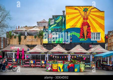 London, Großbritannien - 28. Dezember 2025: Farbenfrohe Fassade des Restaurants Cubana mit lebendigen Wandgemälden. Stockfoto