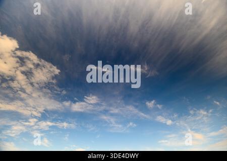 Ein atemberaubender Blick auf einen riesigen Himmel voller sanfter Wolken und lebendiger Blautöne, die Ruhe inspirieren Stockfoto