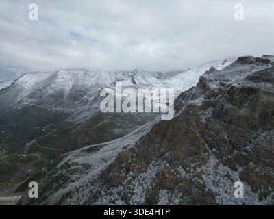 Aus der Vogelperspektive schneebedeckte Gipfel, die majestätisch unter einem stimmungsvollen Himmel aufsteigen, ein ruhiges Panorama der Winterberührung in den Bergen, Siah Bisheh, Mazandaran Stockfoto