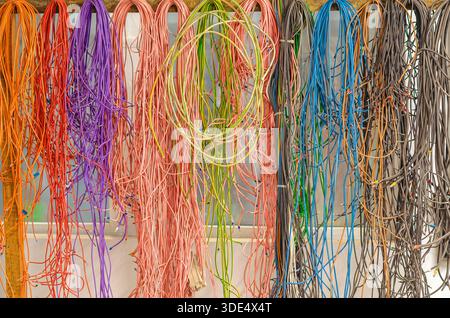 Farbige elektrische Drähte. Bunte elektrische Kabel für elektrische Verkabelungssysteme in modernen Gebäuden. Kabel und Kabel für Strom- und Beleuchtungssystem. Stockfoto