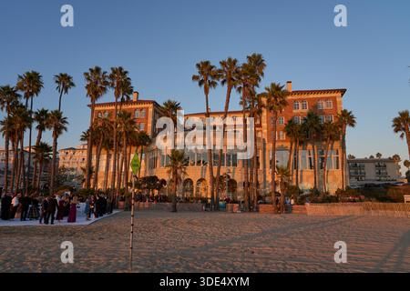 Los Angeles, USA - 18. Oktober 2025 - Hotel Casa del Mar - elegante Hochzeitszeremonie am Strand mit Gästen und Palmen bei Sonnenuntergang Stockfoto