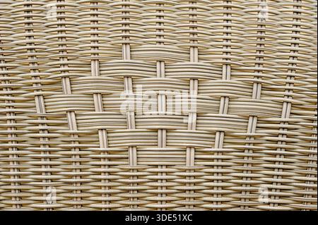 Eine Nahansicht zeigt die komplizierten Details eines gewebten Korbs. Das Werk hebt das Muster und die Textur hervor, die durch die Webstränge gebildet werden. Stockfoto