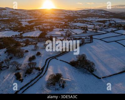 Clwydian Range Hills, Flintshire, North WalesUK Wetter: 5. Januar 2025. Starker Schneefall und starker Frost bis -4,5 in der Nähe des Dorfes Lixwm mit einer kalten Nacht vor dem Sonnenuntergang über den Hügeln der Clwydian Range in Flinthsire, Nordwales. ©DGDImages/Alamy Live News Stockfoto