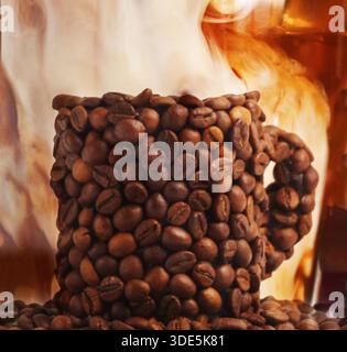 Tasse mit Kaffeebohnen gegen Milchwirbel im Getränk bedeckt Stockfoto