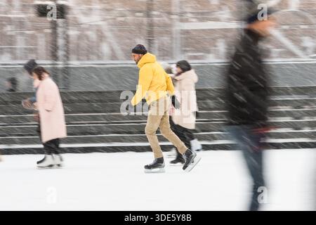 Bärtiger Mann mittleren Alters auf der Eisbahn, draußen an schneebedeckten Wintertagen Stockfoto