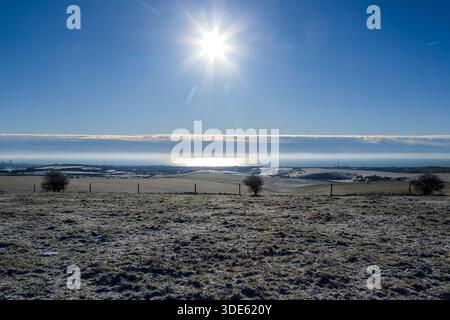 Ein sonniger Wintertag mit Blick auf die Küste in Sussex, mit Schnee auf dem Boden und einem blauen Himmel über dem Himmel Stockfoto