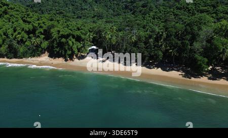 Blick aus der Vogelperspektive auf die Englishman’s Bay in Tobago mit einem abgeschiedenen sicheligen Strand, türkisfarbenem karibischem Wasser und üppigem tropischem Regenwald. Stockfoto