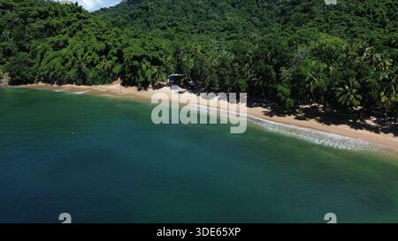 Blick aus der Vogelperspektive auf die Englishman’s Bay in Tobago mit einem abgeschiedenen sicheligen Strand, türkisfarbenem karibischem Wasser und üppigem tropischem Regenwald. Stockfoto