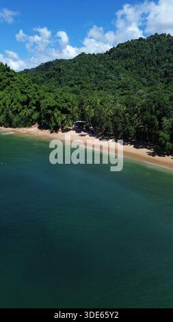 Blick aus der Vogelperspektive auf die Englishman’s Bay in Tobago mit einem abgeschiedenen sicheligen Strand, türkisfarbenem karibischem Wasser und üppigem tropischem Regenwald. Stockfoto