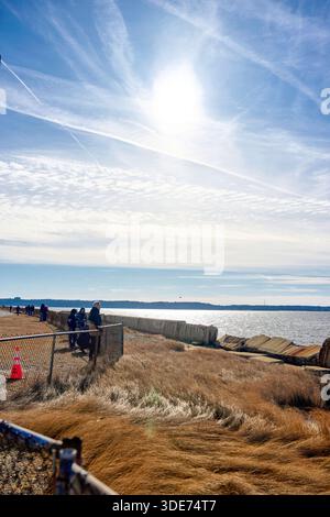 Eine Reihe von Zuschauern steht an einem kalten Ufer auf der Suche nach Robben. Aufgenommen in Sandy Hook, Monmouth County, New Jersey, USA. Stockfoto