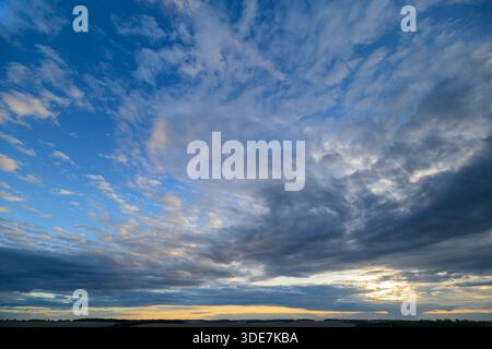 Ein atemberaubender Blick auf einen lebendigen, dynamischen Himmel, der bei einem atemberaubenden Sonnenuntergang mit dramatischen Wolken gefüllt ist Stockfoto