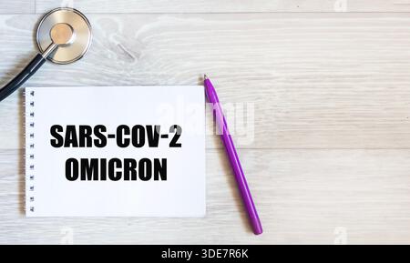 Omicron SARS-CoV-2. Auf dem Notebook befindet sich ein Eintrag Omicron SARS-CoV-2 auf weißem Hintergrund. Der Begriff der Medizin Stockfoto