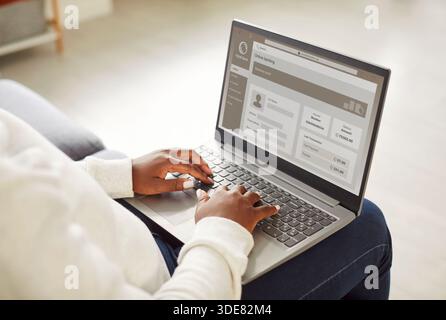 Frau, die Online-Einkäufe tätigt und Online-Banking mit Laptop zu Hause genießt. Stockfoto