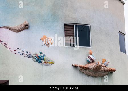3D-Figuren von Flamingos, Schildkröten und Fischen, hergestellt aus Keramikfliesen, dekoriert eine Gebäudefassade, Puerto Baquerizo Moreno, San Cristóbal ist Stockfoto