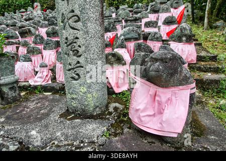 Kyoto, Japan, 10/04/2016 Beschreibung: Aus nächster Nähe sehen Sie zahlreiche buddhistische Steinstatuen (Jizo) mit traditionellen rosa Votivschürzen. Stockfoto