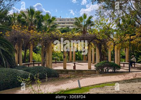 Benalmadena, Spanien - 24. Dezember 2025: Dieses Stockfoto zeigt eine ruhige Parkszene in Benalmadena Costa del Sol Spanien mit Pergolen und Bänken Stockfoto